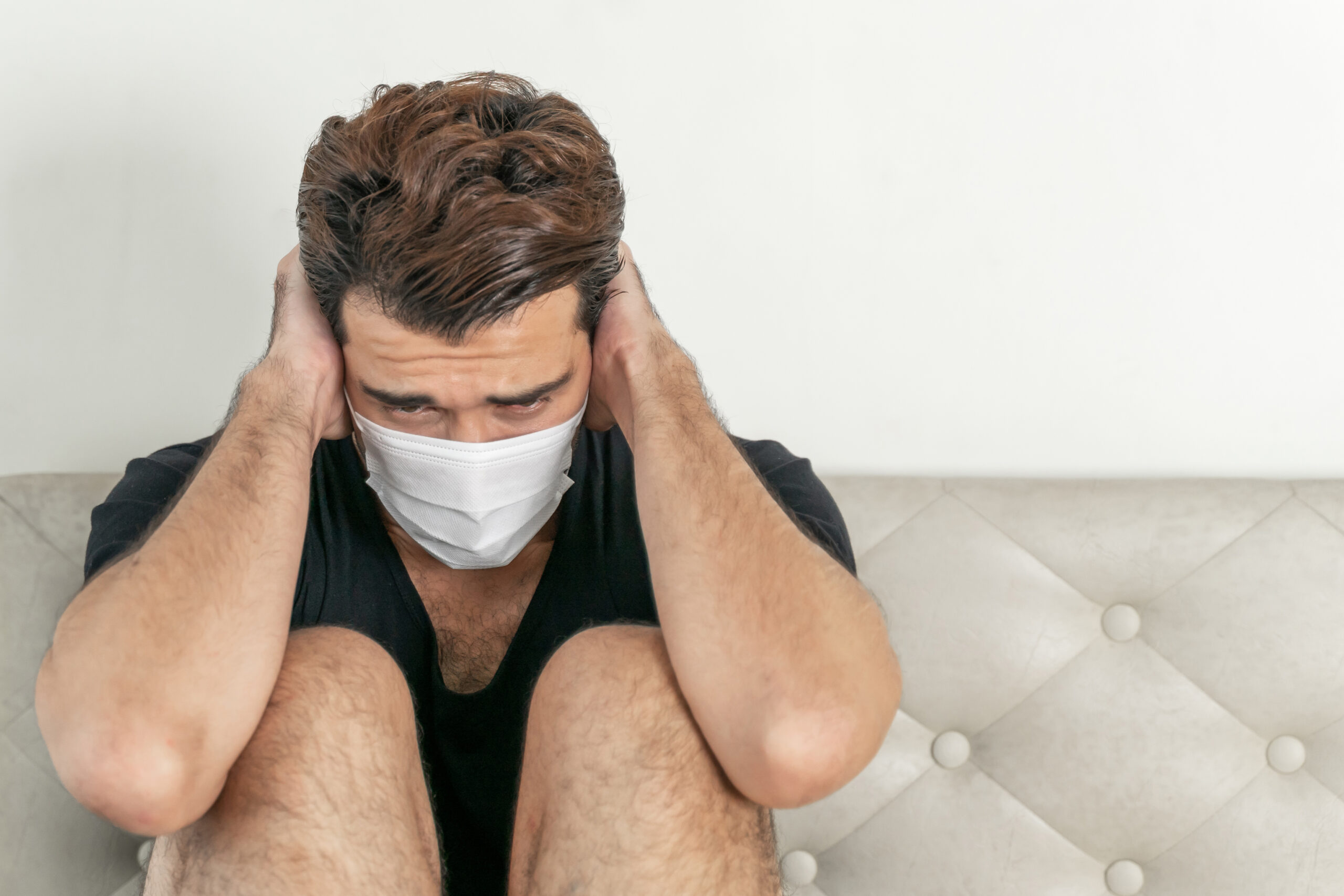 hombre-con-mascarilla-para-proteger-la-sensacion-de-malestar-dolor-de-cabeza-y-tos-debido-al-coronavirus-covid-19-en-la-sala-de-cuarentena
